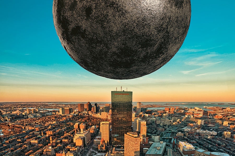 A large, dark, textured spherical object hovers low over a cityscape at sunset, with tall buildings and a body of water visible in the distance under a clear blue sky.
