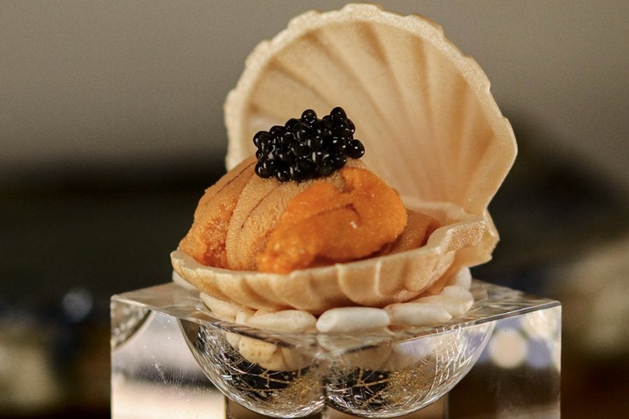Uni and caviar served in a decorative shell during an omakase meal.